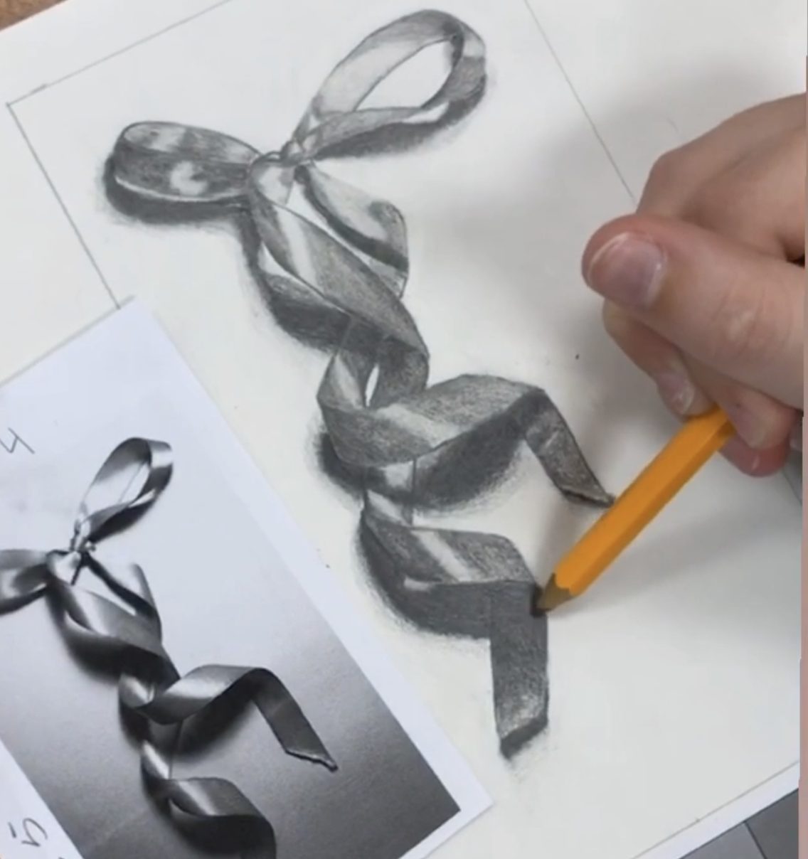 someone drawing a satin ribbon using pencil shading techniques from a beginner drawing and shading lesson by Tiffany Fox of Mrs. T. Fox Resources beginner drawing curriculum on TpT